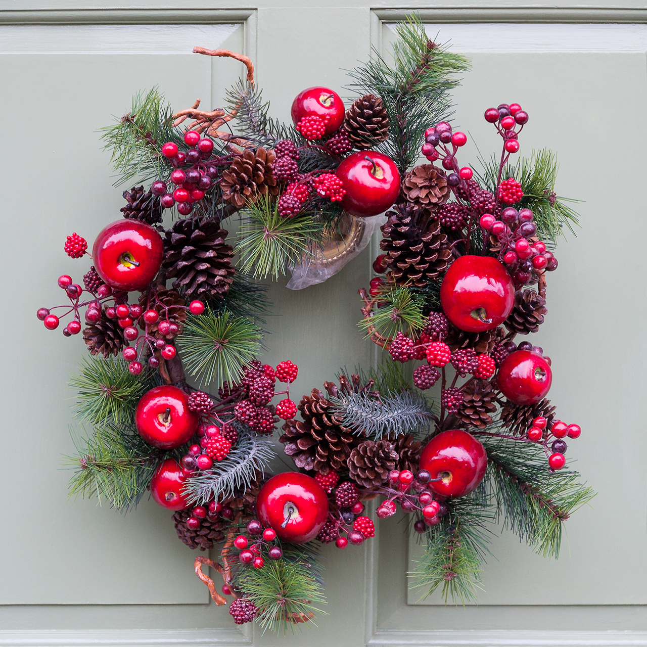 Christmas wreath with pine branches, pinecones and apples
