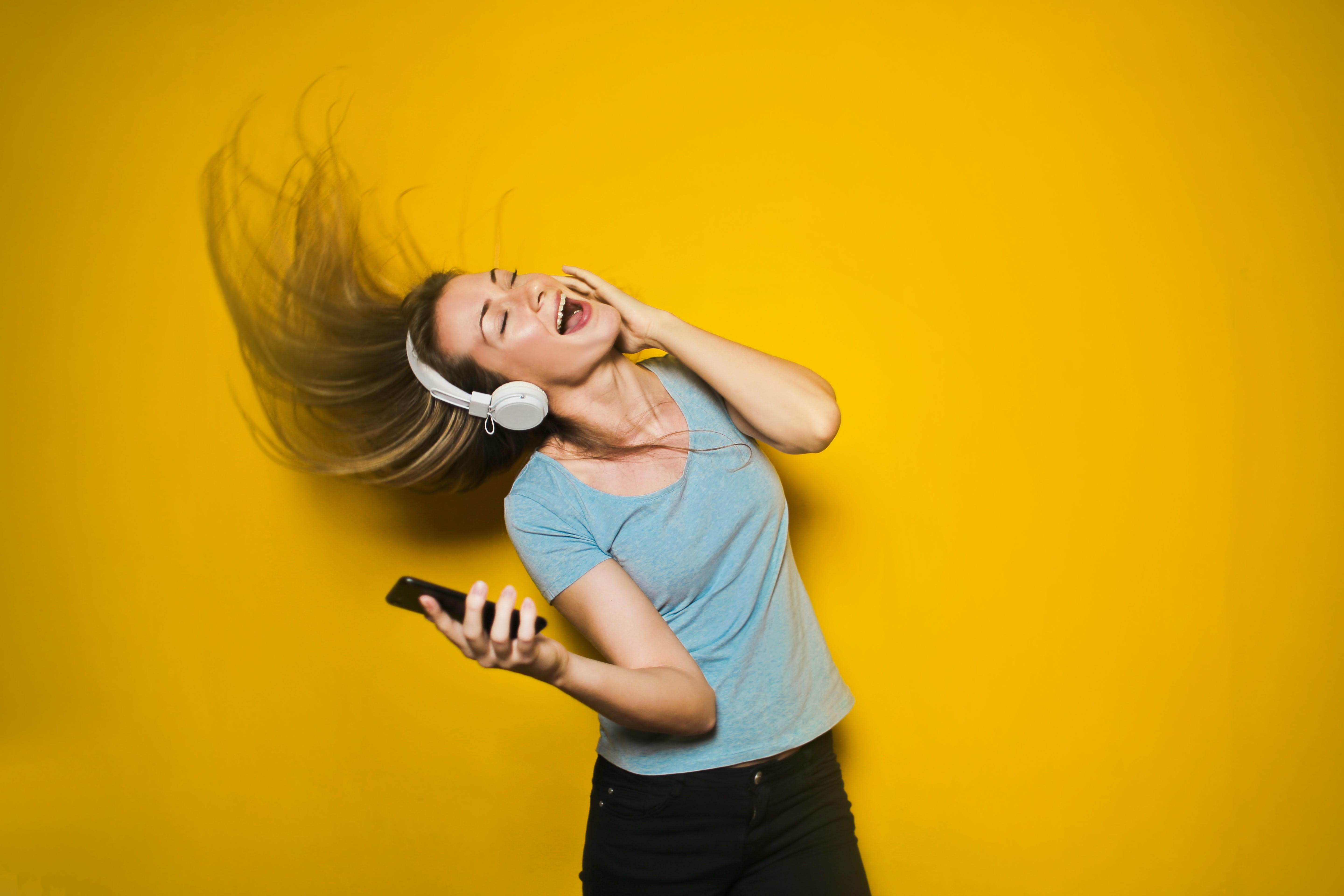 woman dancing to music on yellow background