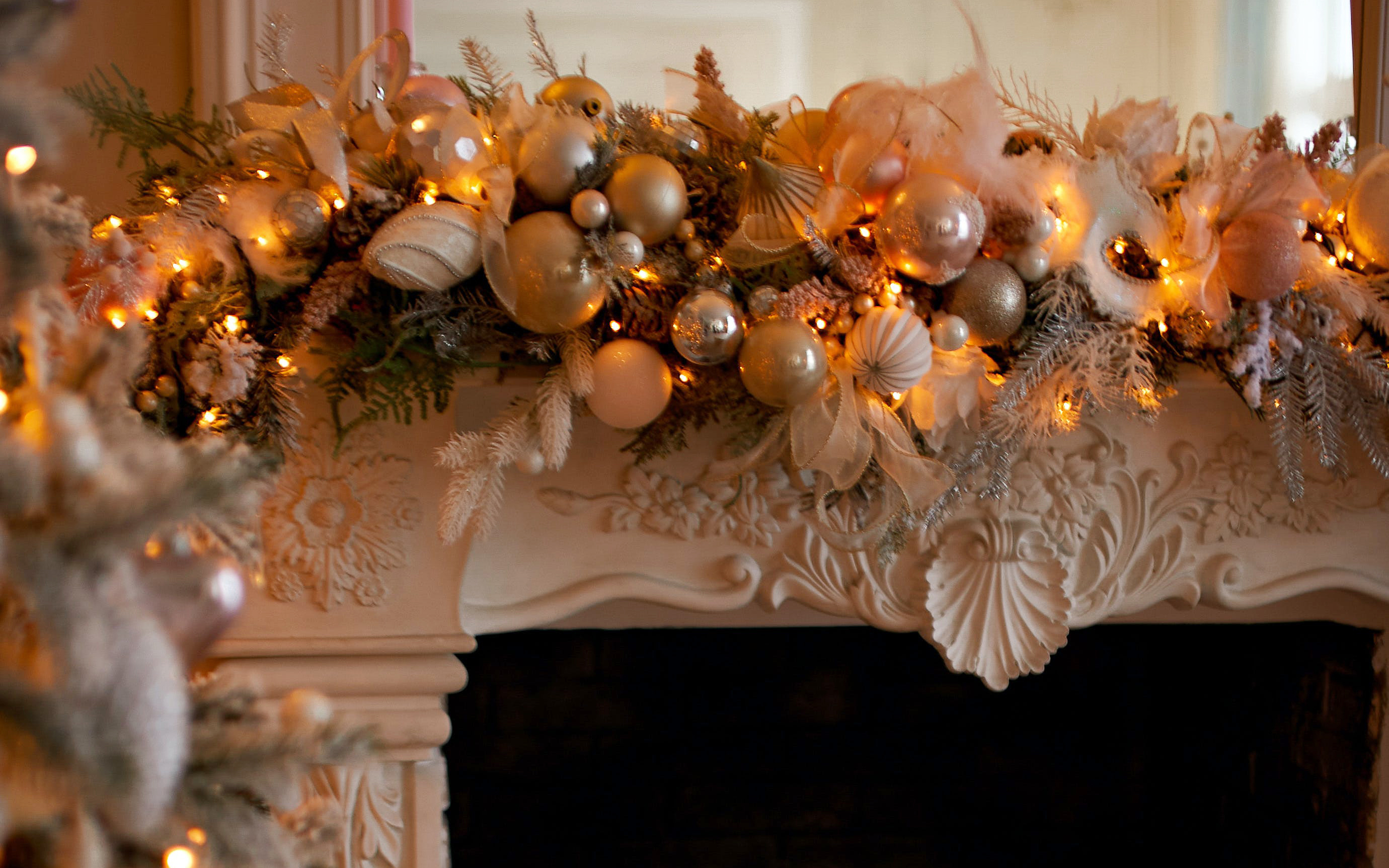 Ornate fireplace mantel opulently decorated with gold and silver ornaments and soft white mini lights Ornate fireplace mantel opulently decorated with gold and silver ornaments and soft white mini lights