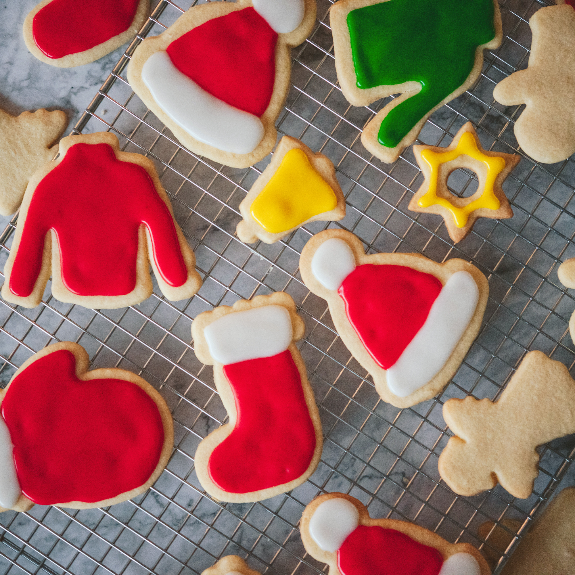 colorfully decorated Christmas cookies on baking rack