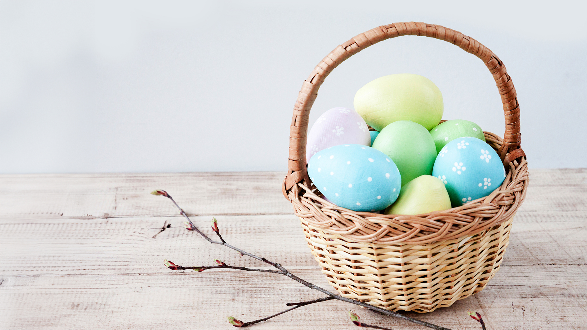 Natural colored woven Easter basket filled with pretty pastel Easter eggs
