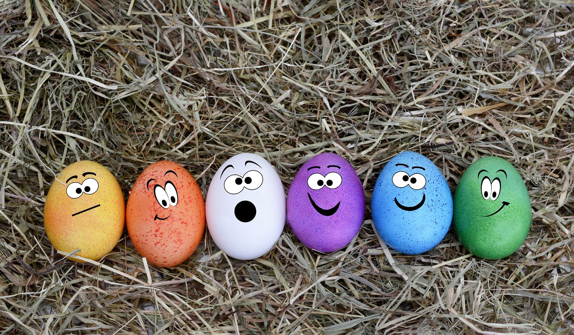 painted easter eggs lying in hay