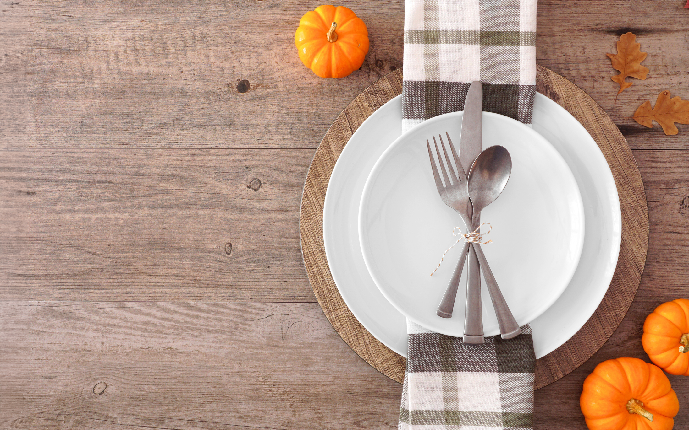 lovely table setting with brown plaid napkin and orange mini pumpkins