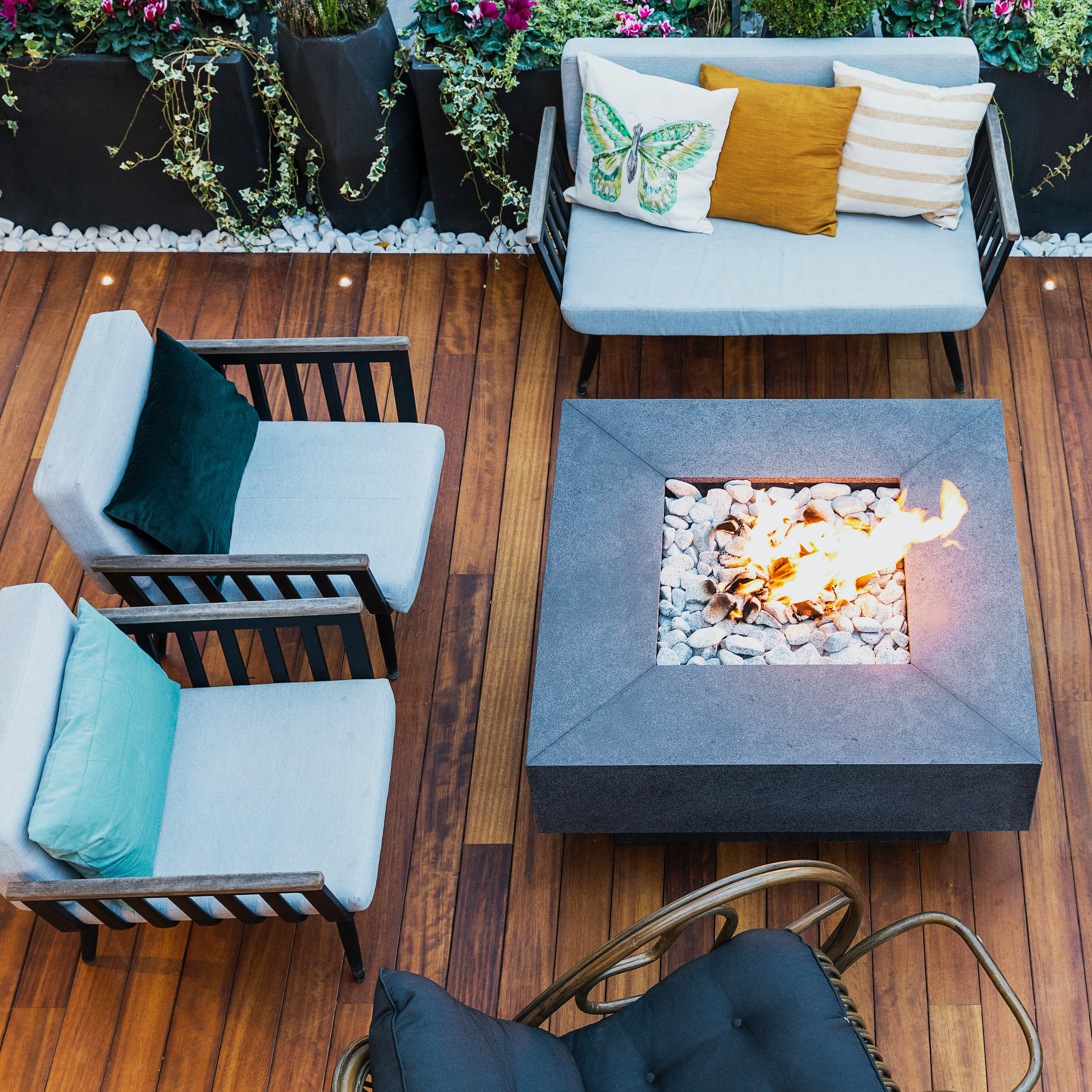 overhead view of open deck with patio furniture and square fire pit table