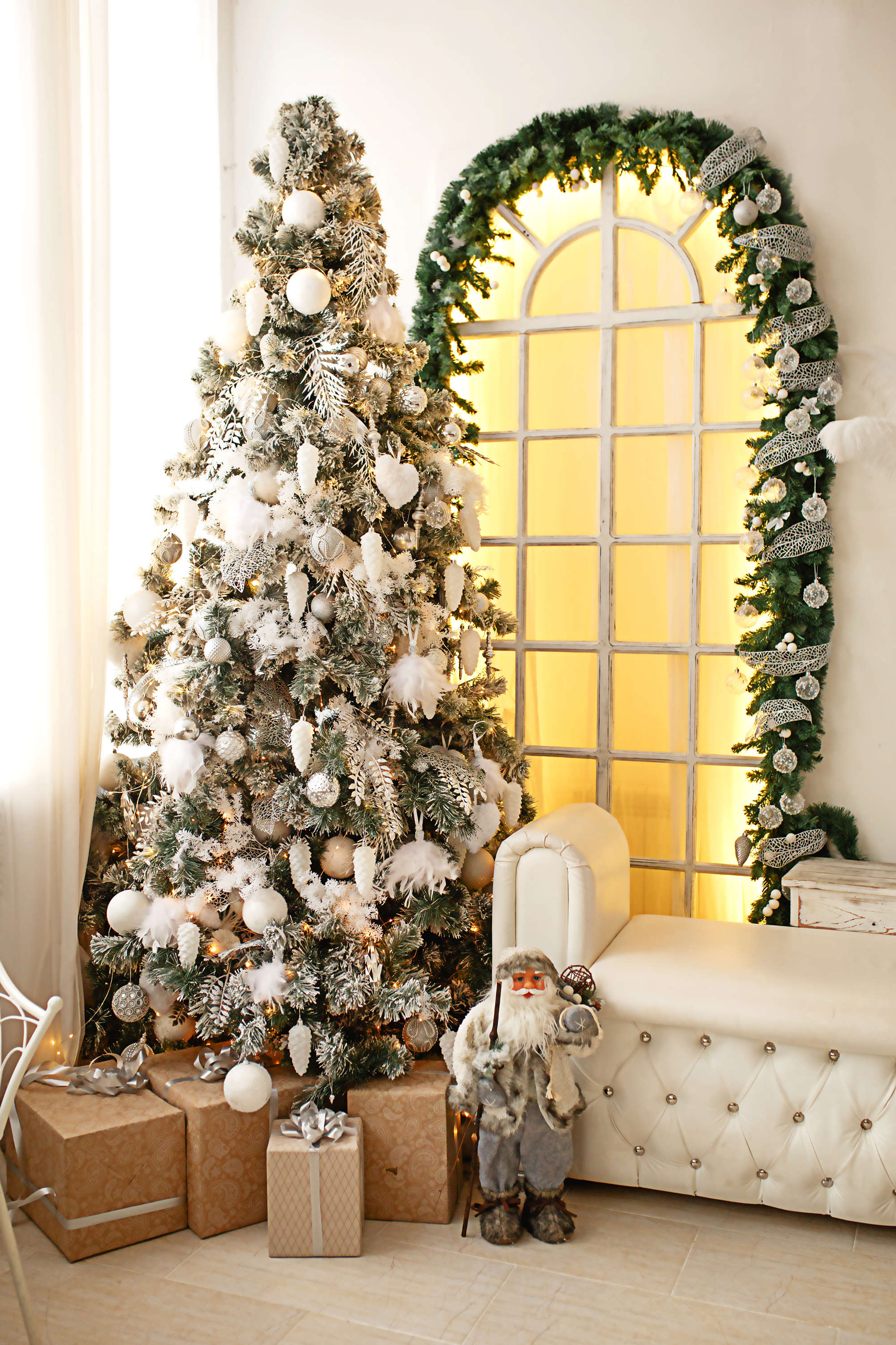 garland framing interior arched window near decorated Christmas tree