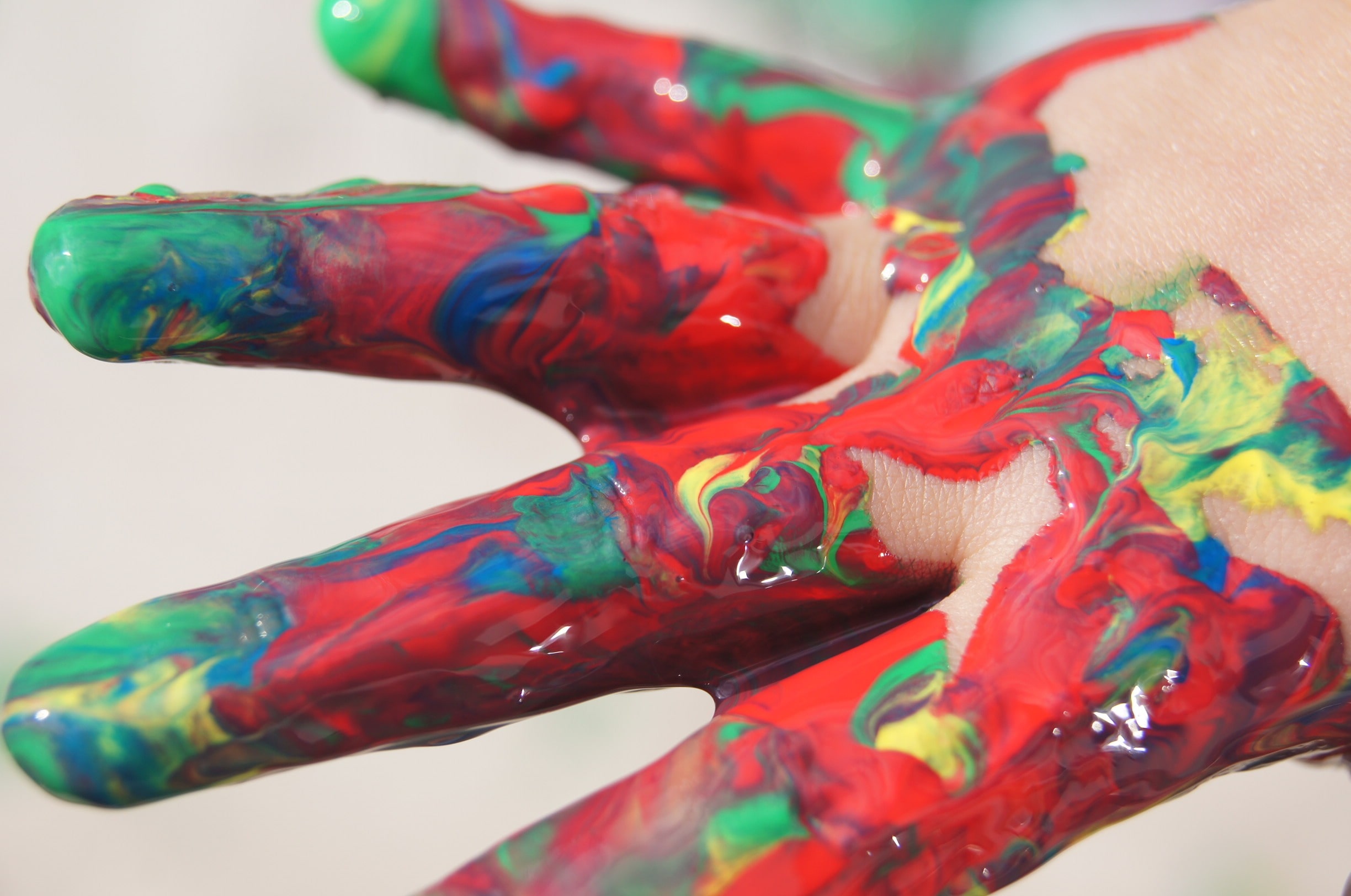 child's hands covered in paint