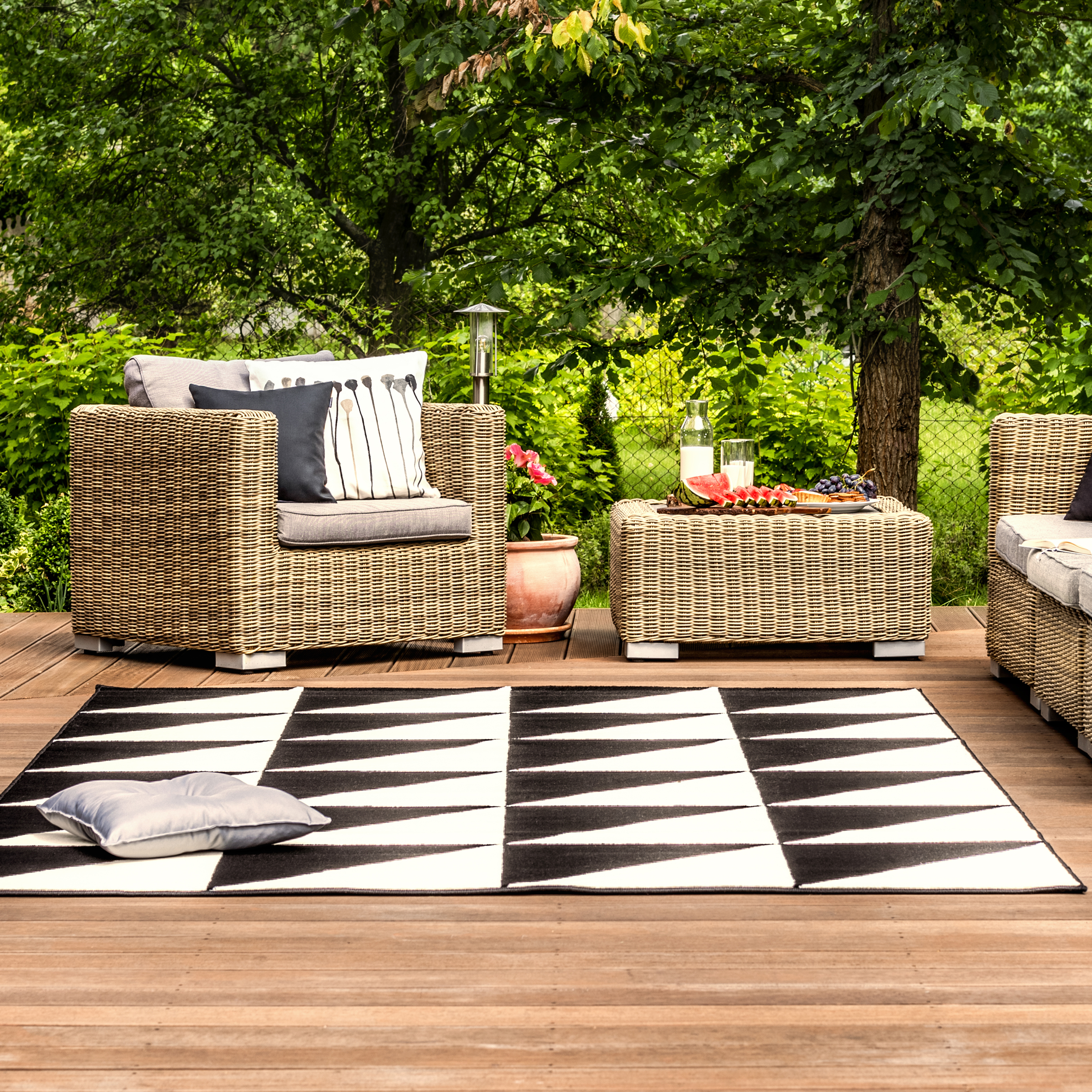 deck with outdoor furniture and black and white outdoor area rug