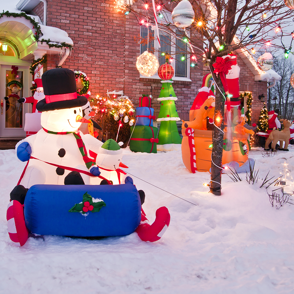 Christmas inflatables on a snowy front lawn