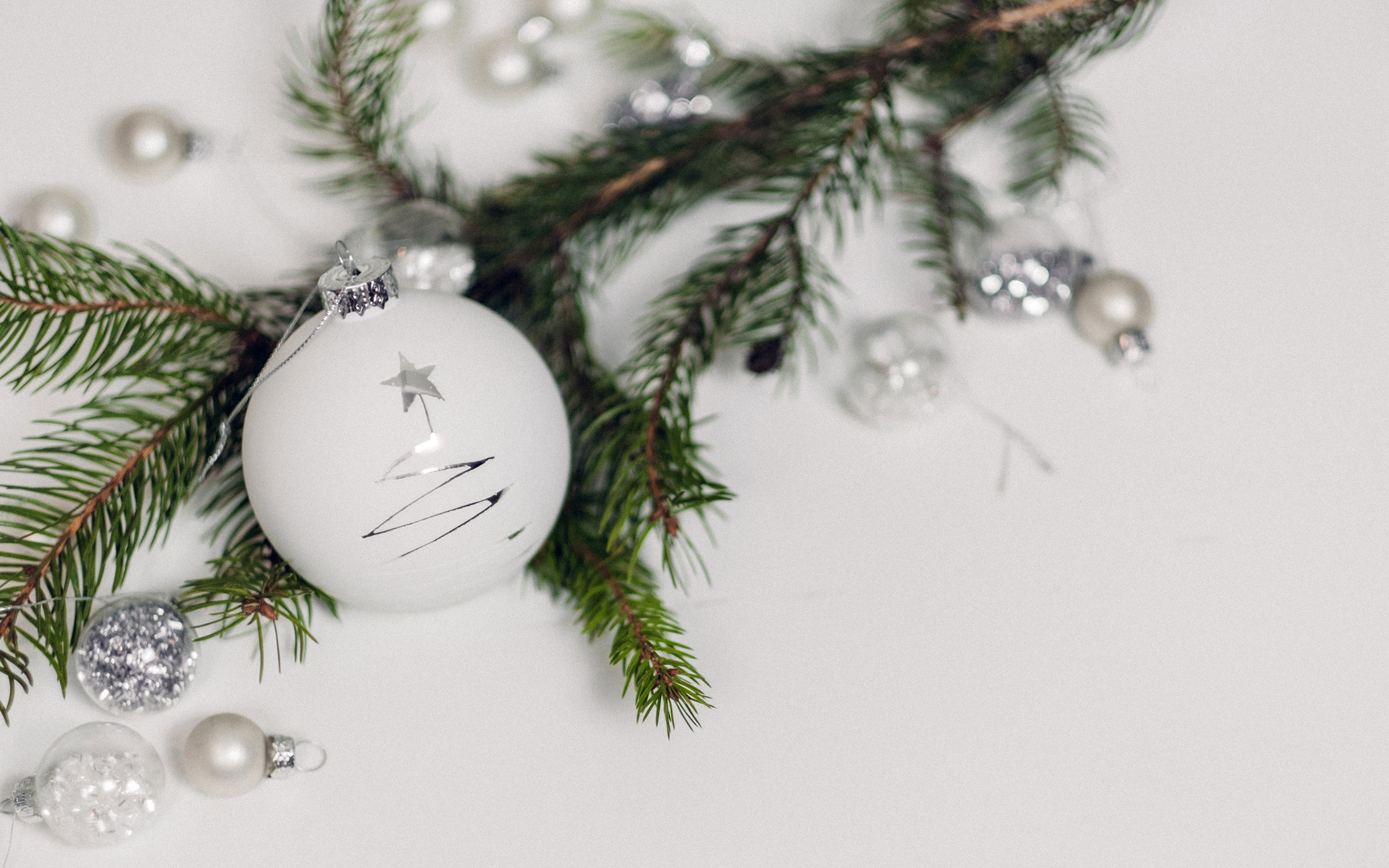 fresh white Christmas ornaments with green pine bough